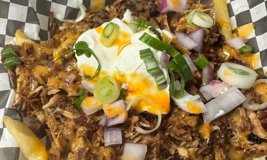Loaded adobo fries topped with cheese, onions, sour cream and ABG sauce