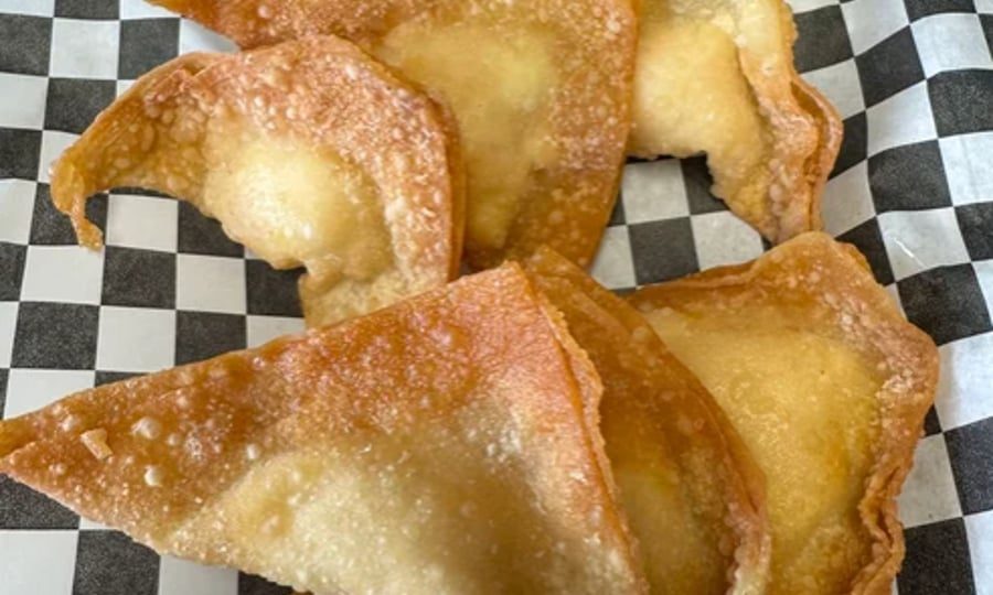 Golden fried crab rangoon on checkered paper